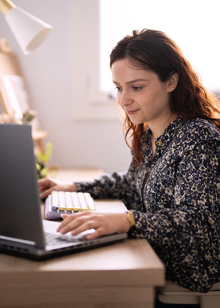 Photo de Chloé Garrigue en train de travailler à son bureau, devant un ordinateur